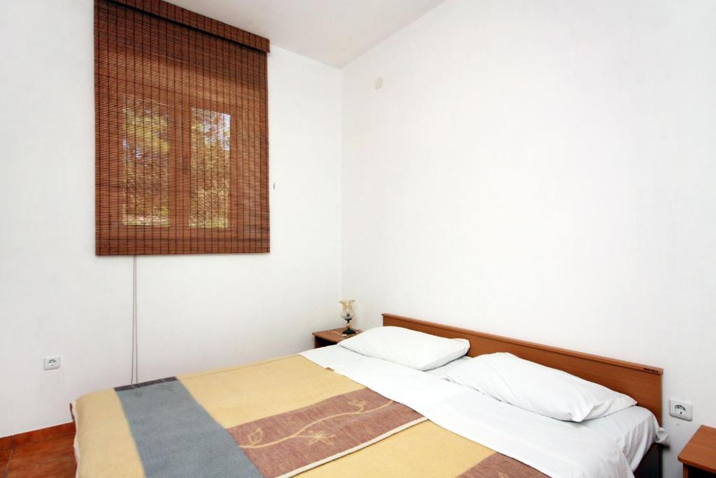 ein Schlafzimmer mit 2 Betten und einem Bild an der Wand in der Unterkunft Apartment Pomena 10426b in Goveđari