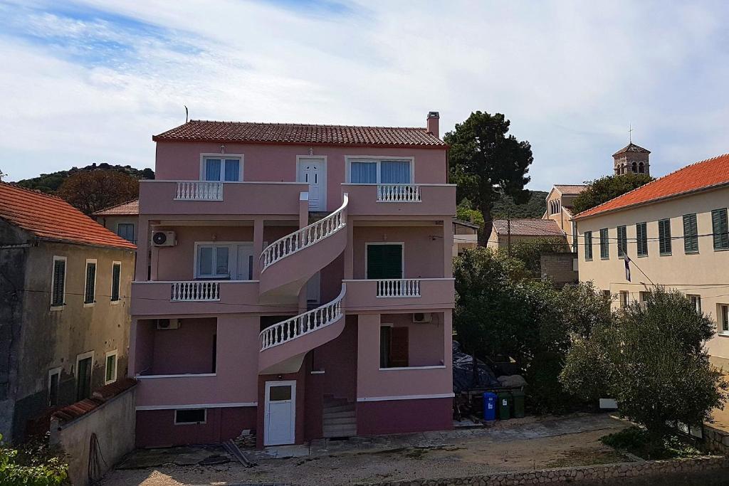 a pink building with balconies on the side of it at Apartments by the sea Tkon, Pasman - 8414 in Tkon