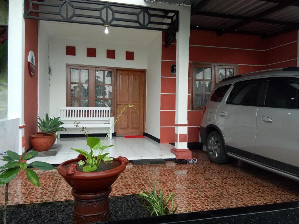 a white van parked in front of a house at Argolawu Homestay in Tawangmangu