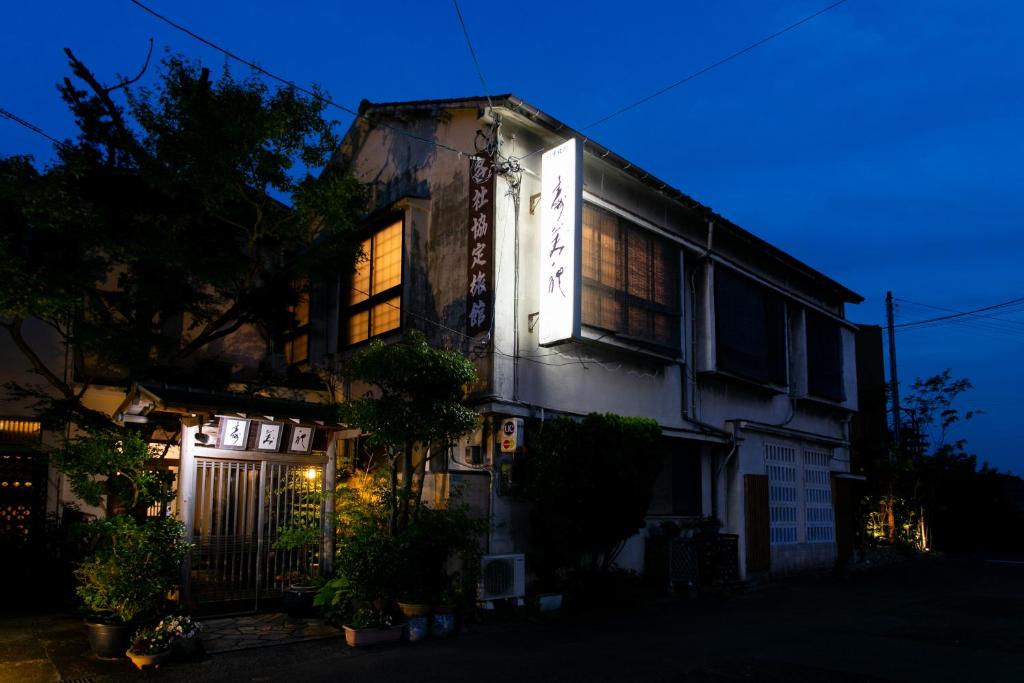una casa iluminada por la noche con luces encendidas en Hotel Sumire ふぐ料理を愉しむ料理宿, en Shimonoseki