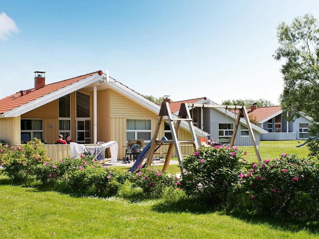 オッテルンドルフにある12 person holiday home in Otterndorfの中庭の滑り台付き家