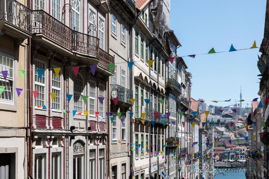 a city street with buildings with colorful flags at ICON Duplo Ribeira in Porto