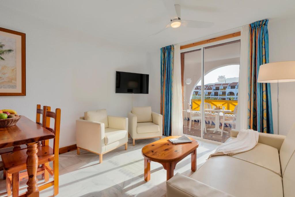 a living room with a couch and a table at Parque Santiago III Official in Playa de las Americas