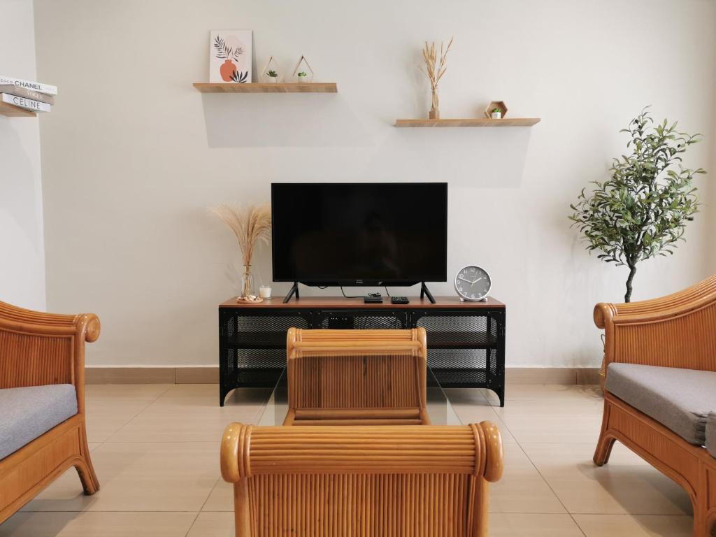 a living room with a tv and two chairs at 28 Residence Homestay in Melaka