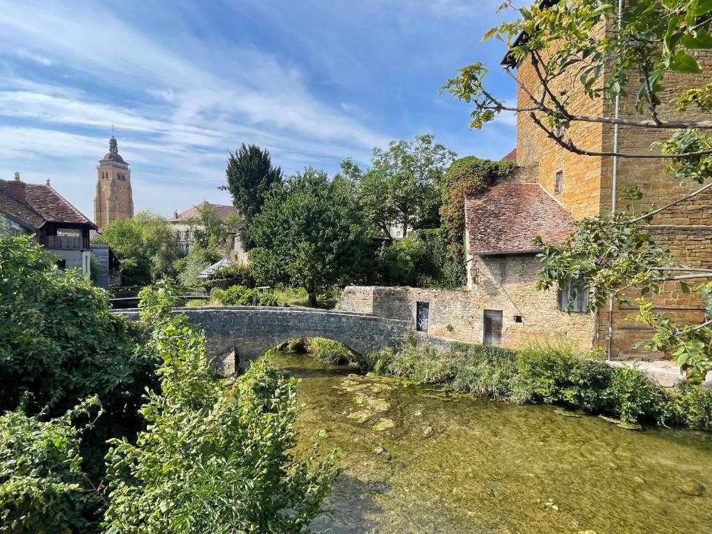 un puente de piedra sobre un río en un pueblo en Maison près de la rivière, en Arbois