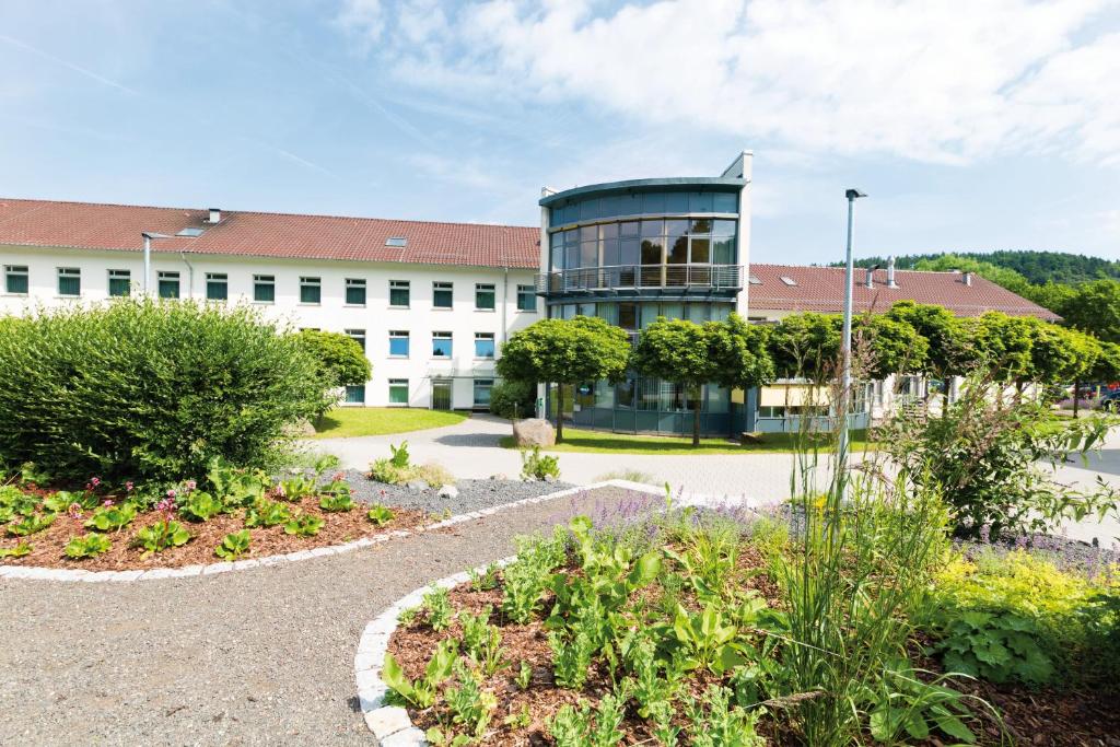 un bâtiment avec un jardin en face dans l'établissement DEULA Witzenhausen GmbH, à Witzenhausen