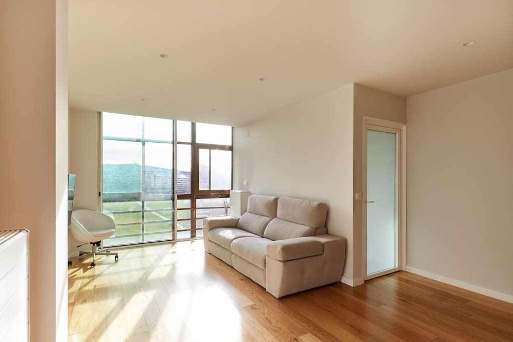 sala de estar con sofá y ventana grande en Apartamento Singular Deluxe, en Pamplona