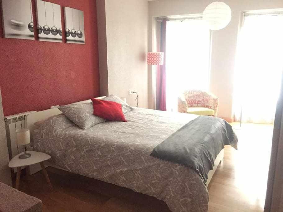 Un dormitorio con una cama con almohadas. en Apartamento Ayla Ayuntamiento, en Pamplona