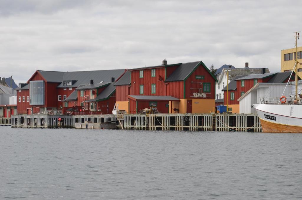 a group of houses next to the water with a boat at Skjæret rorbu in Stamsund