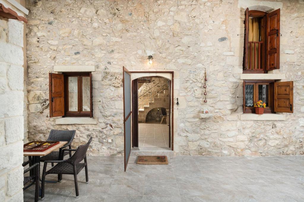 a stone building with a doorway and a table and chairs at Pagonas Traditional House in Mouríon