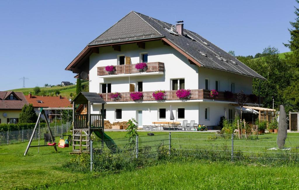 una casa blanca con un parque infantil delante de ella en Apartment Haus Sagerer near Attersee and Mondsee en Strass im Attergau