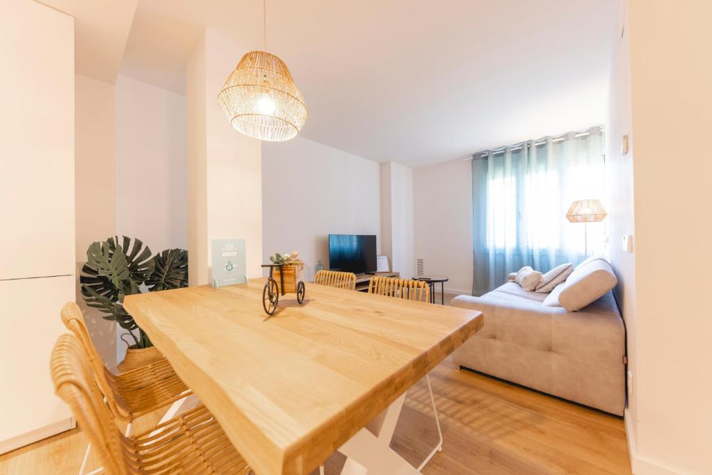 ein Esszimmer und ein Wohnzimmer mit einem Holztisch in der Unterkunft Bravissimo Sirenes, 2-bedroom apartment in Girona