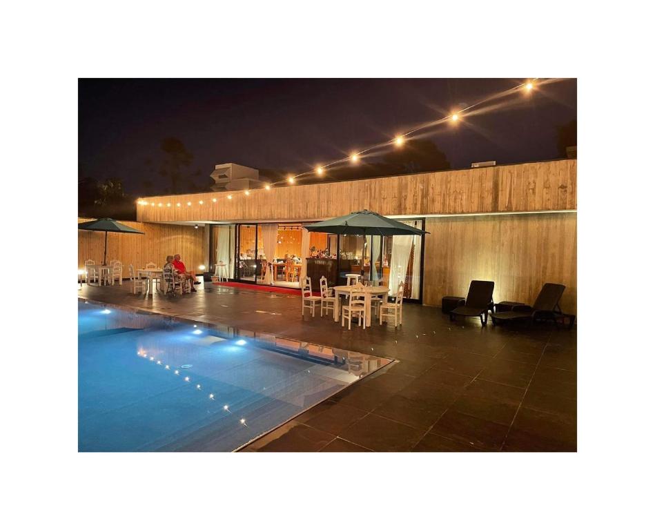 a swimming pool with tables and chairs and an umbrella at Solar Do Conde in Capelas