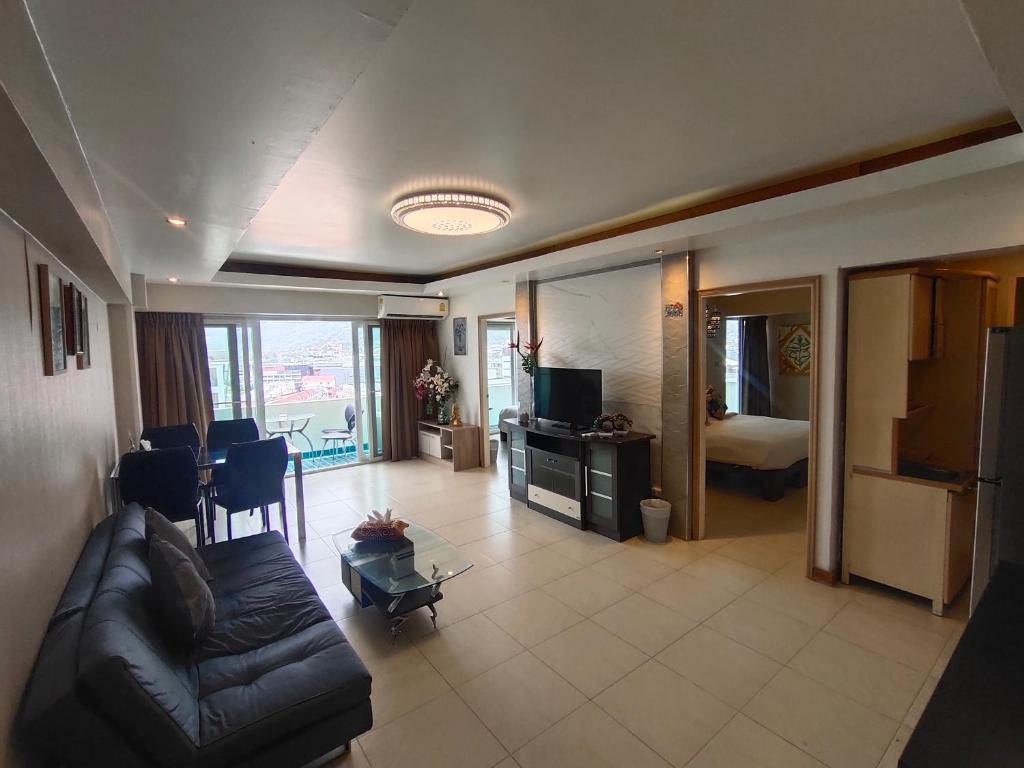 a living room with a couch and a room with a bed at Condo Minium Patong Phuket in Patong Beach