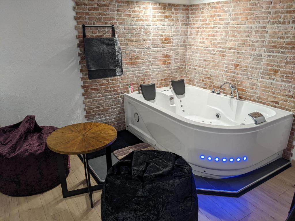 a bath tub in a room with a brick wall at Lodge du Léman in Sciez