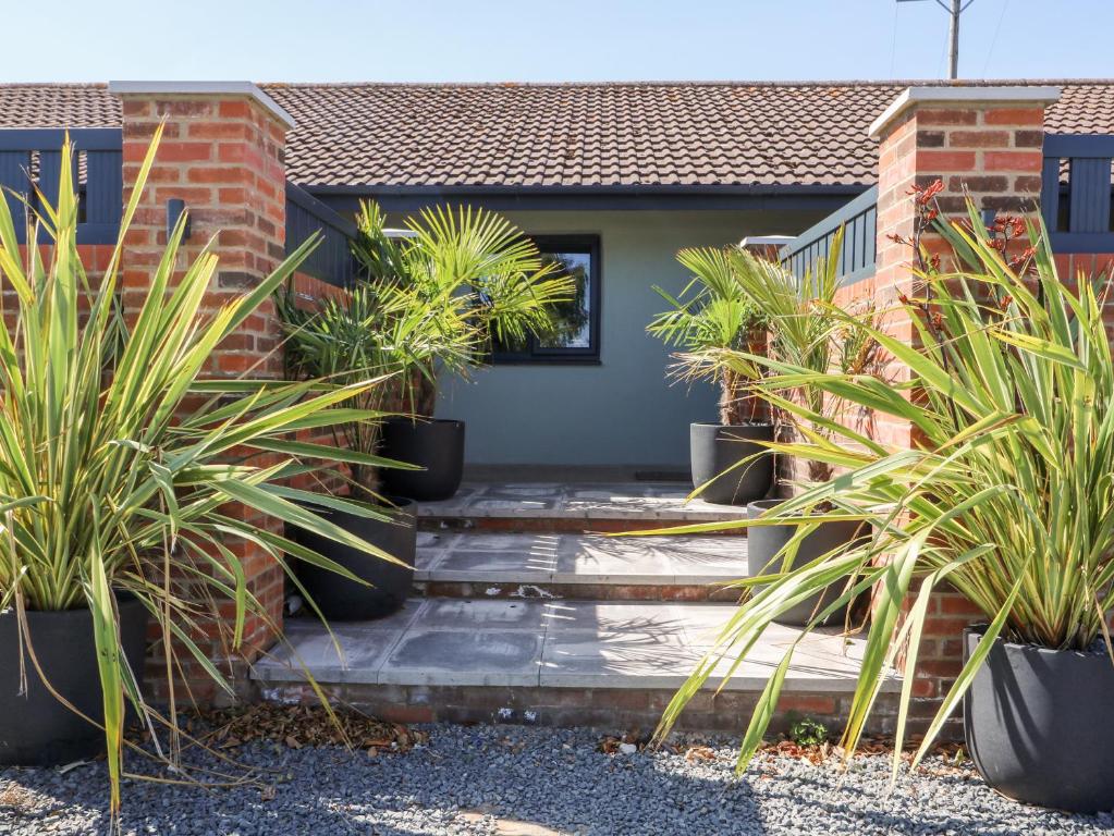a house with potted plants on the front porch at Chalet 3 in Ganton