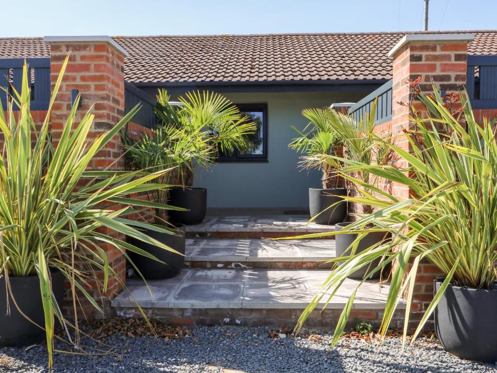 a house with potted plants on the front porch at Chalet 1 in Ganton