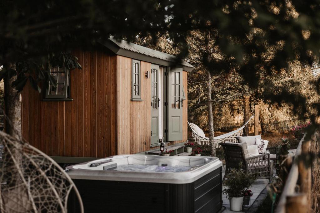 einen Whirlpool auf der Terrasse eines Hauses in der Unterkunft The Dragonfly Shepherds Hut in Colchester