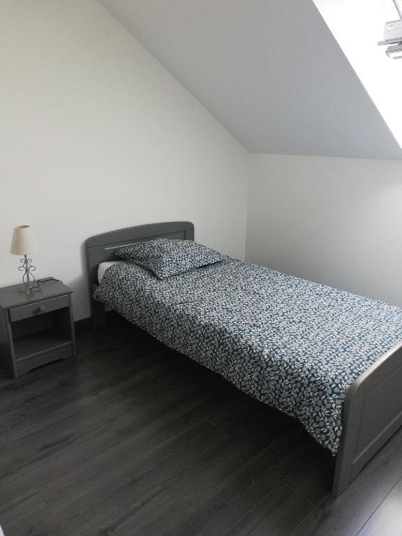 a bedroom with a bed and a side table at La Ruelle : chambres d&#39;hôtes in Saumur