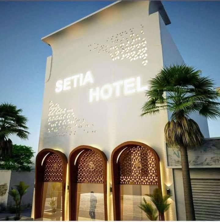 un hôtel avec un palmier en face dans l'établissement SETIA HOTEL, à Malaut