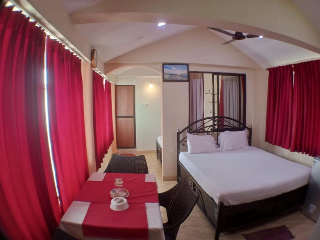 mały pokój z łóżkiem i stołem w obiekcie Goan Delicacy Guest House w mieście Panaji