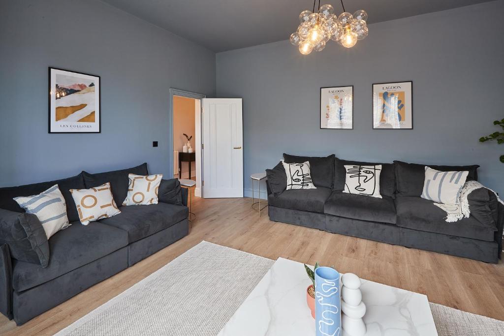a living room with a black couch and a table at Host & Stay - Parkside Villa in Harrogate