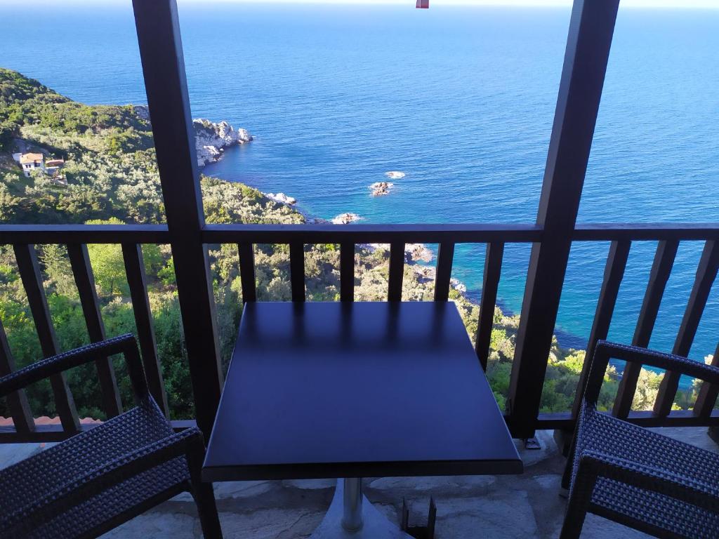 a table and chairs on a balcony overlooking the ocean at Double studio room in front of the sea in Tsagarada