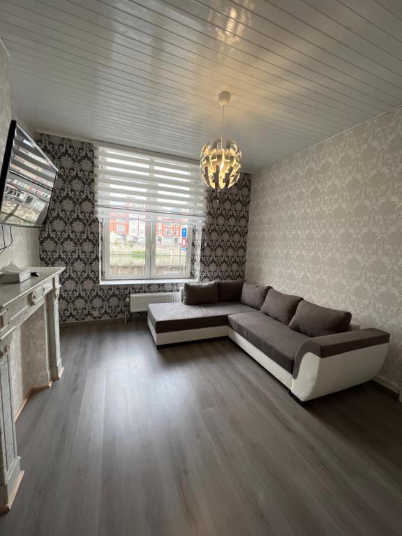 un grand salon avec un canapé et un lustre dans l'établissement Proche de tout lieux touristiques à Liège, à Liège