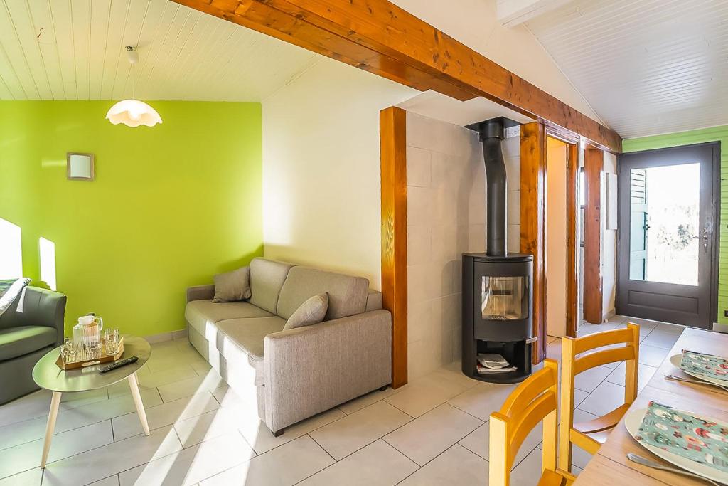 - un salon avec un canapé et un poêle à bois dans l'établissement Village de gîtes de la Forêt de Ganigal, au Malzieu-Ville