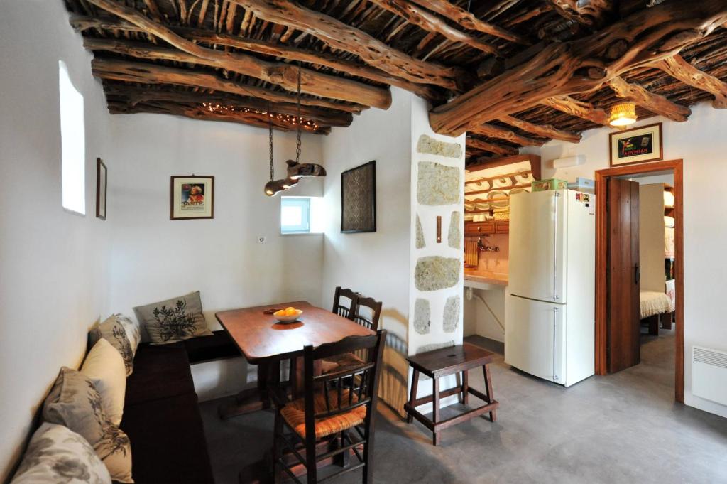 a kitchen and living room with a table and a refrigerator at Giourgas Cottage Milos Island in Ralaki