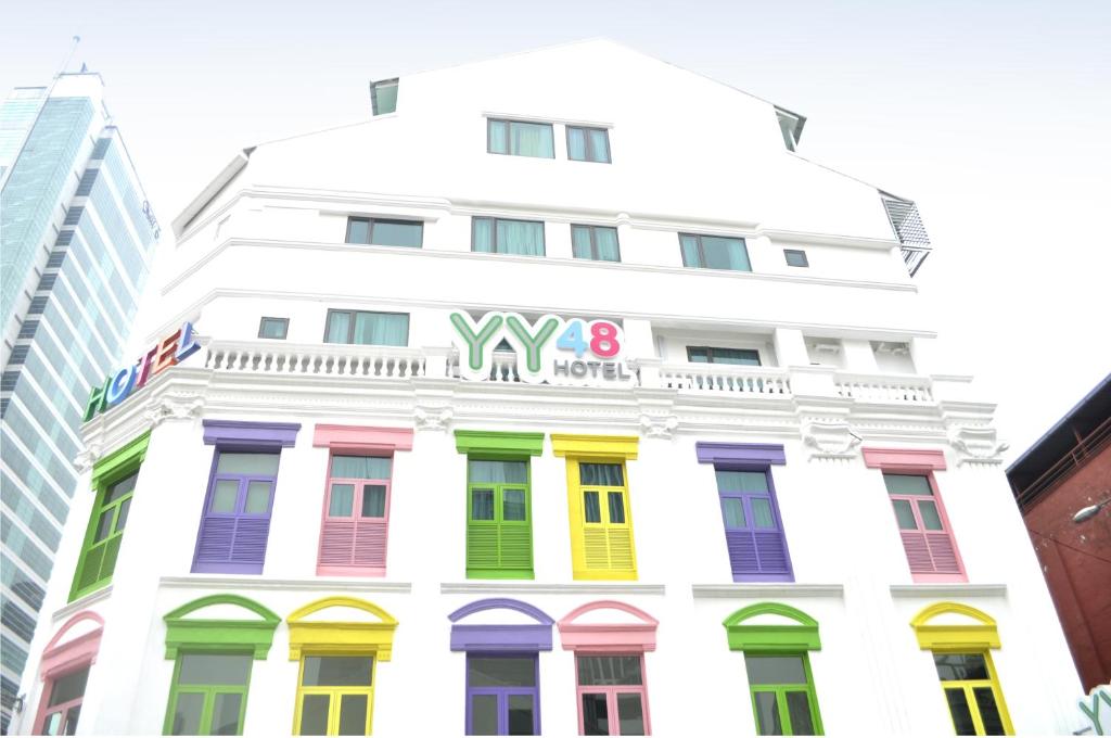 een wit gebouw met kleurrijke ramen bij YY48 Hotel 2 Mins Walk From Masjid Jamek LRT Station in Kuala Lumpur