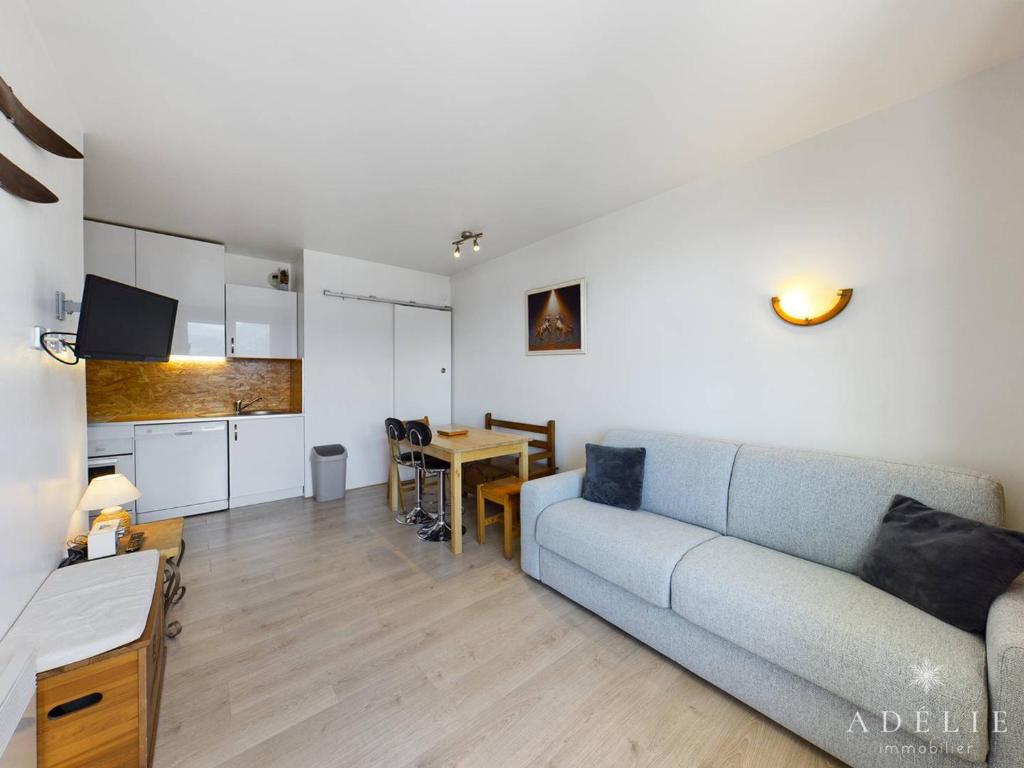een woonkamer met een blauwe bank en een tafel bij Appartement Montvalezan-La Rosière, 2 pièces, 5 personnes - FR-1-398-567 in La Rosière