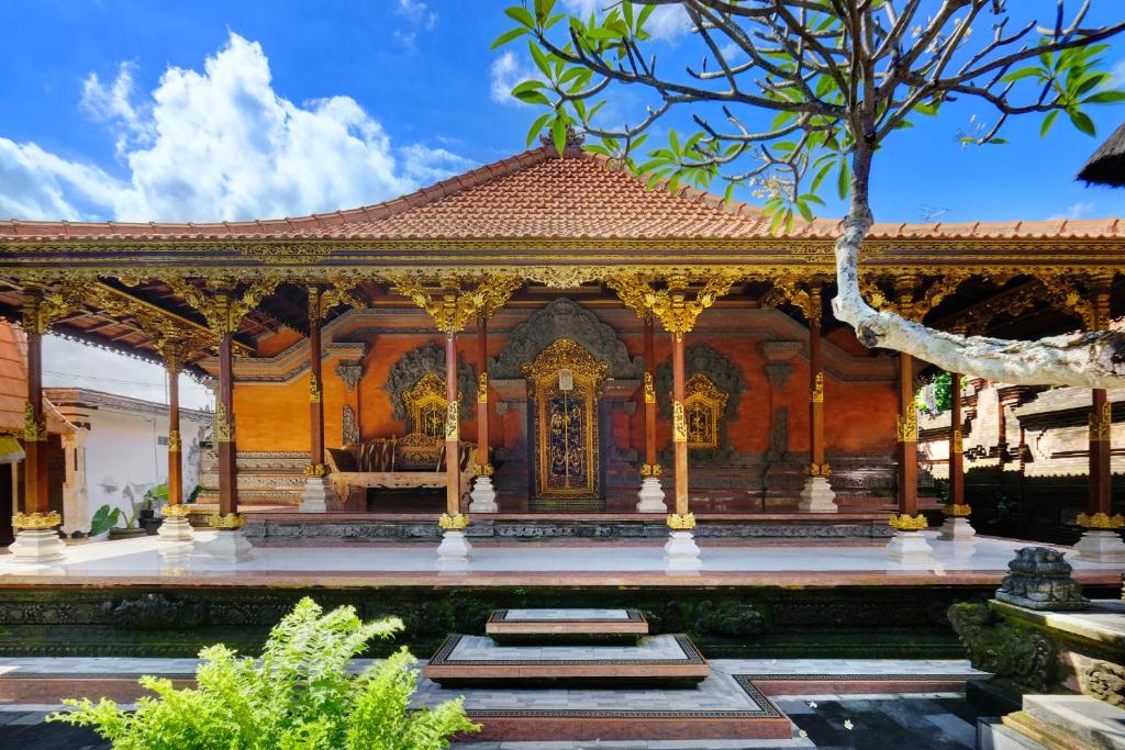 een tempel in een tuin met een boom bij Jero Delod Kedungu in Tabanan