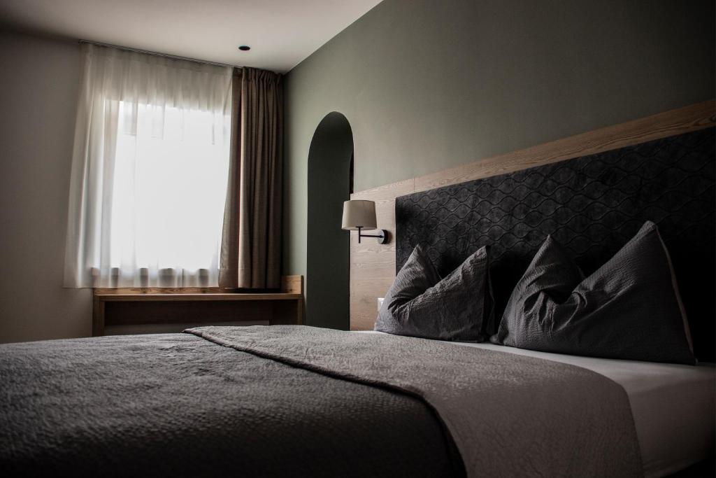 - une chambre avec un grand lit et une fenêtre dans l'établissement DolceAmbiez Apartments, à Dorsino