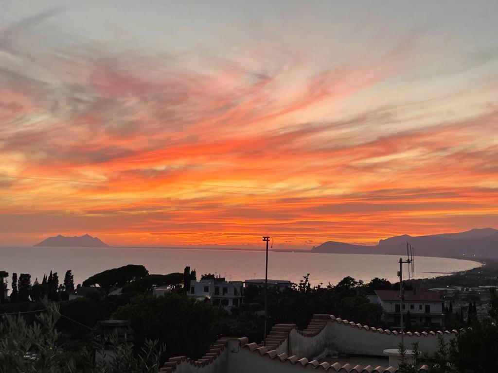 a sunset over the ocean with mountains in the background at Hotel Belvedere in Sperlonga