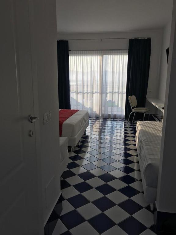 a hotel room with two beds and a checkered floor at Hotel Belvedere in Sperlonga