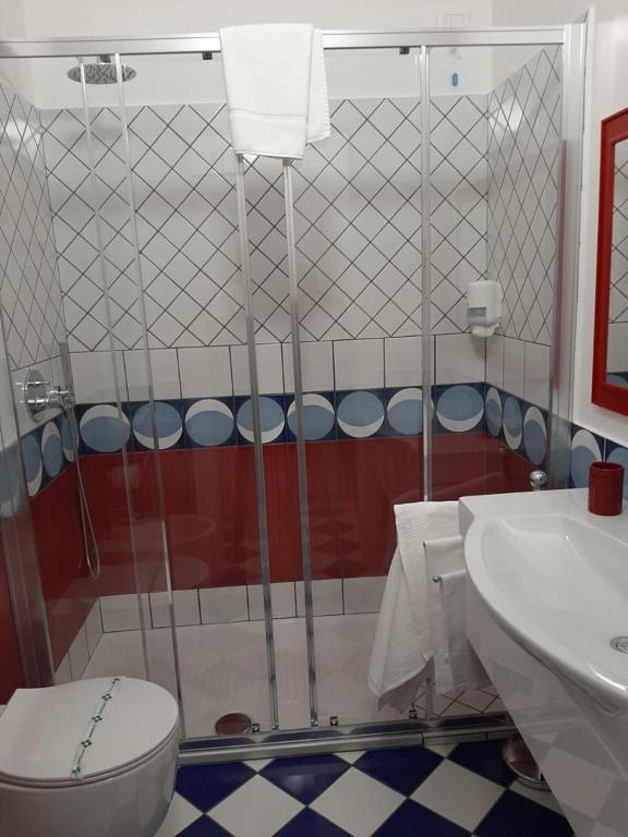 a bathroom with a shower and a toilet and a sink at Hotel Belvedere in Sperlonga