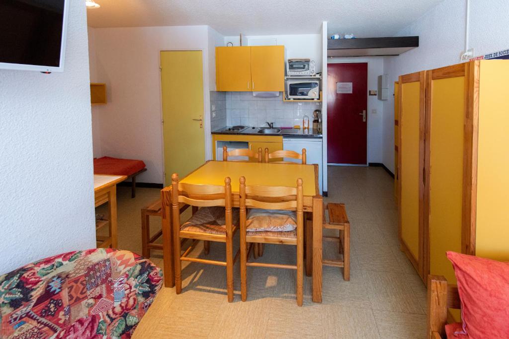uma cozinha e sala de jantar com mesa e cadeiras em Appartement Chabrières em Réallon