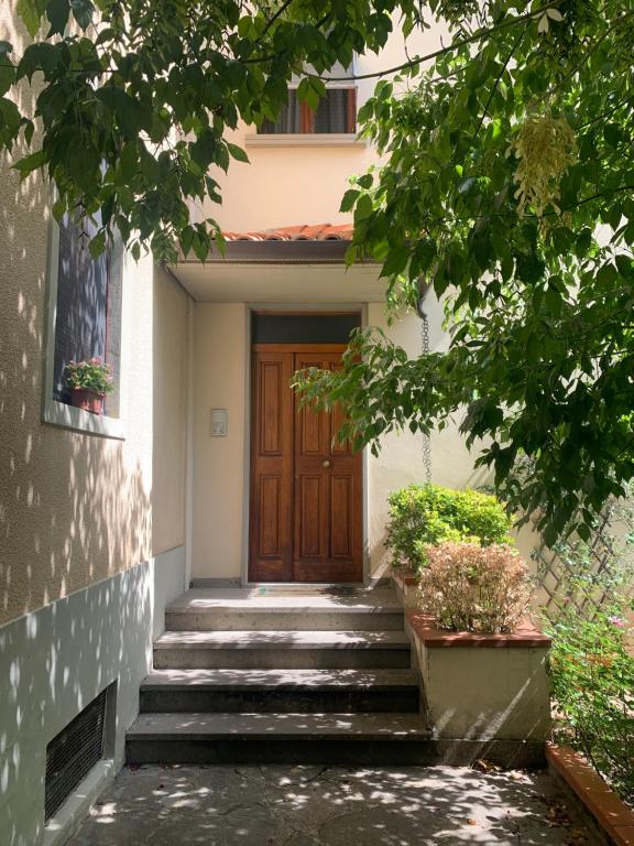 schody prowadzące do domu z drewnianymi drzwiami w obiekcie Home53 w Arezzo