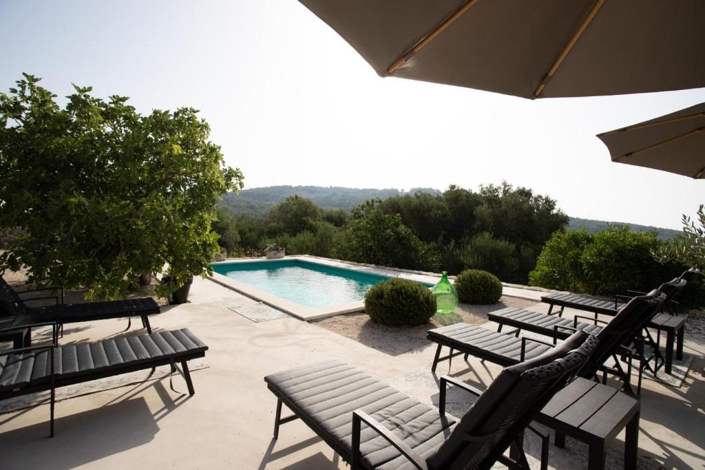 a swimming pool with benches and a swimming pool at Casa Katrida in Selca