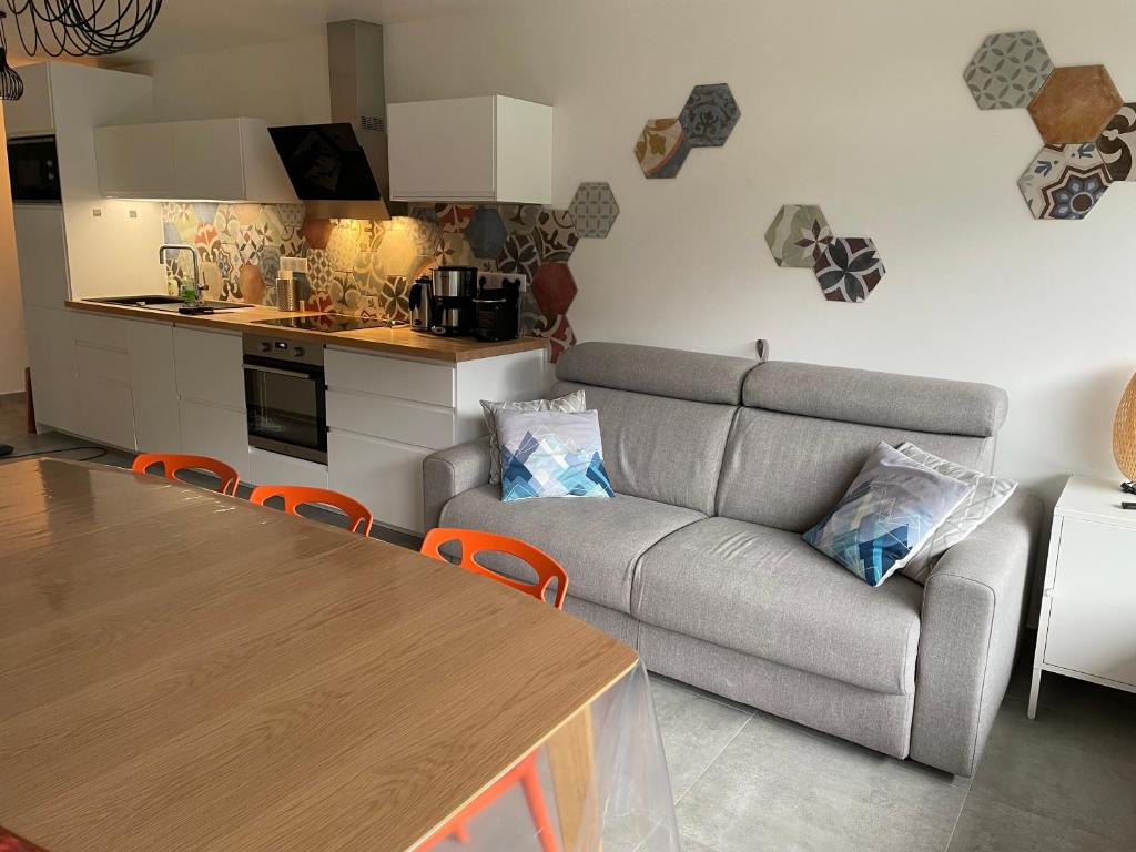 a living room with a couch and a table and a kitchen at Charmant appartement 3 pièces - 6 personnes in Châtel