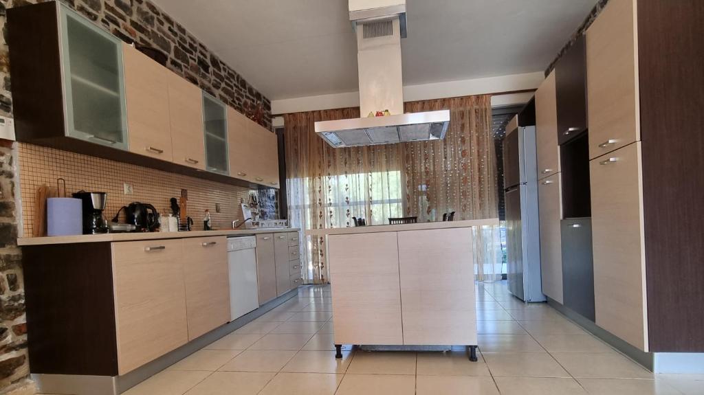 a large kitchen with white cabinets and a tile floor at Villa Vigneto 