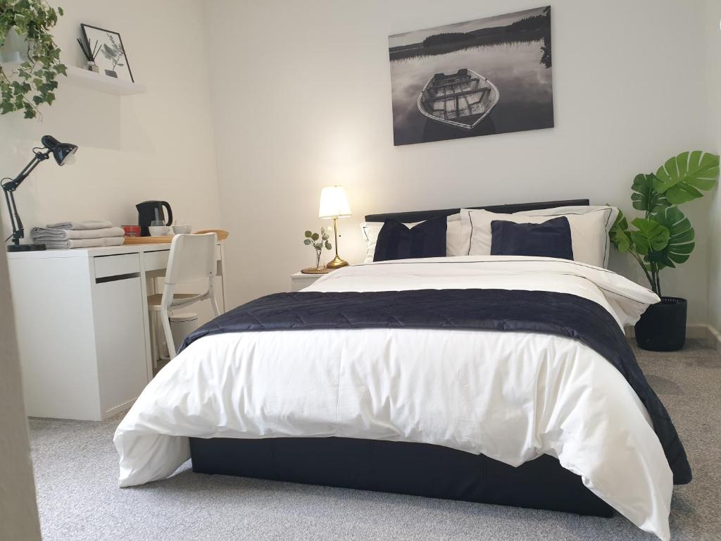a bedroom with a black and white bed and a desk at Tropicana House in Barnsley