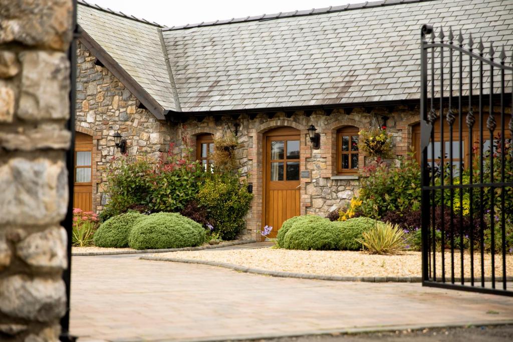 a stone house with a wooden door and a gate at Mulberry House in Swansea