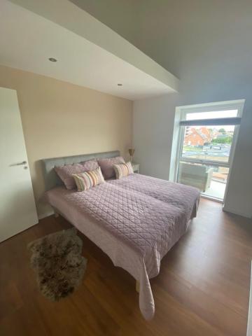 een slaapkamer met een bed in een kamer met een raam bij Søbyen in Skanderborg