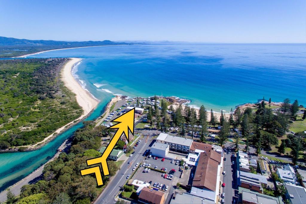 an aerial view of a beach with a yellow arrow pointing to a house at Northpoint Apartment 5 in South West Rocks