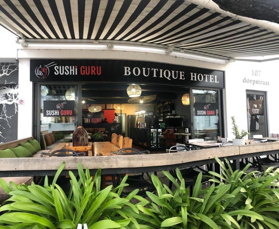 un hotel boutique gurú del sushi con plantas frente a él en 107 Dorpstraat Boutique Hotel en Stellenbosch