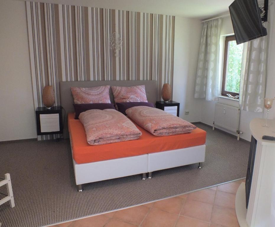 1 dormitorio con 1 cama con 2 almohadas en Ferienwohnung Freyas Walderlebnis, en Stromberg