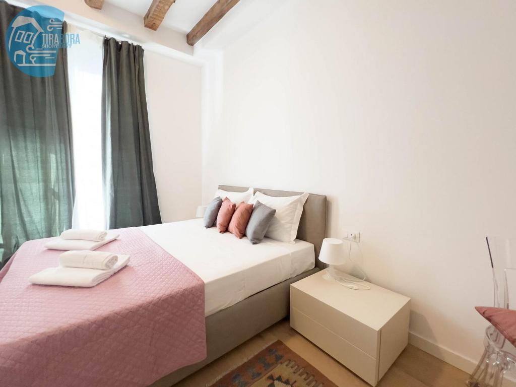 ein Schlafzimmer mit einem rosa Bett und einem Fenster in der Unterkunft Cavana 5 Tirabora Short Rent in Triest