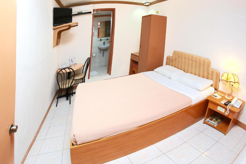 een kleine kamer met een bed en een badkamer bij Elegant Circle Inn in Cebu City